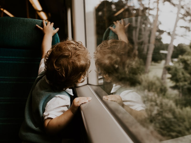 conditions-de-voyage-tarifs-compagnies_billet train enfant - enfant sur un siege dans un train cote fenetre